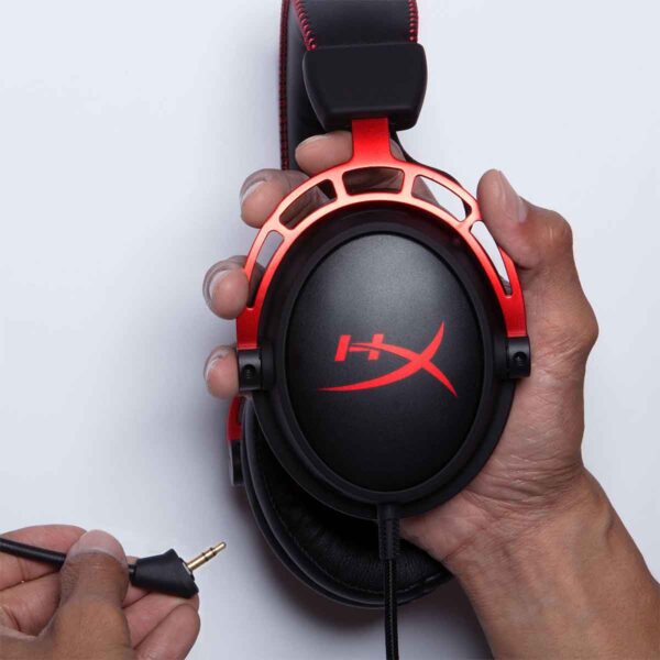 mano sosteniendo un auriculares hyperx cloud alpha conectandole el microfono